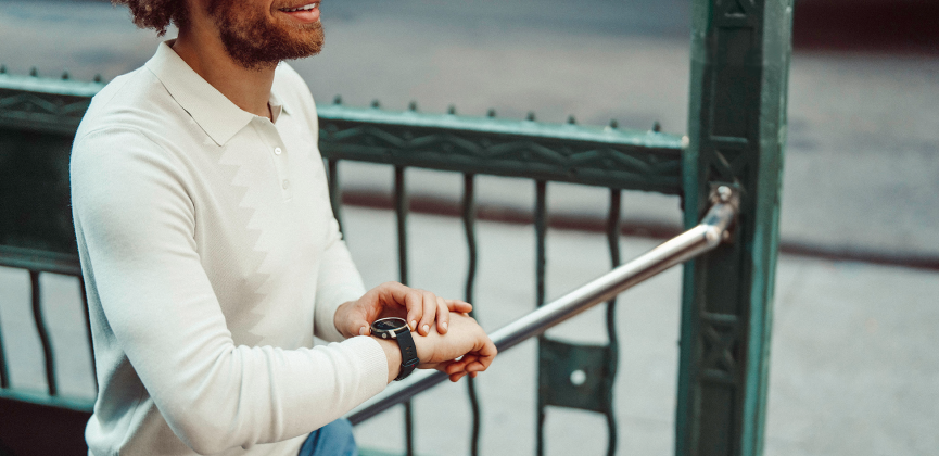 A man checking his sports watch outside in the city